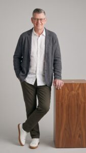 Frank Weißbeck, Inhaber von Feinform Webdesign, lächelt in lockerem Business-Outfit vor neutralem Studio-Hintergrund – Webdesign und SEO für Fulda.